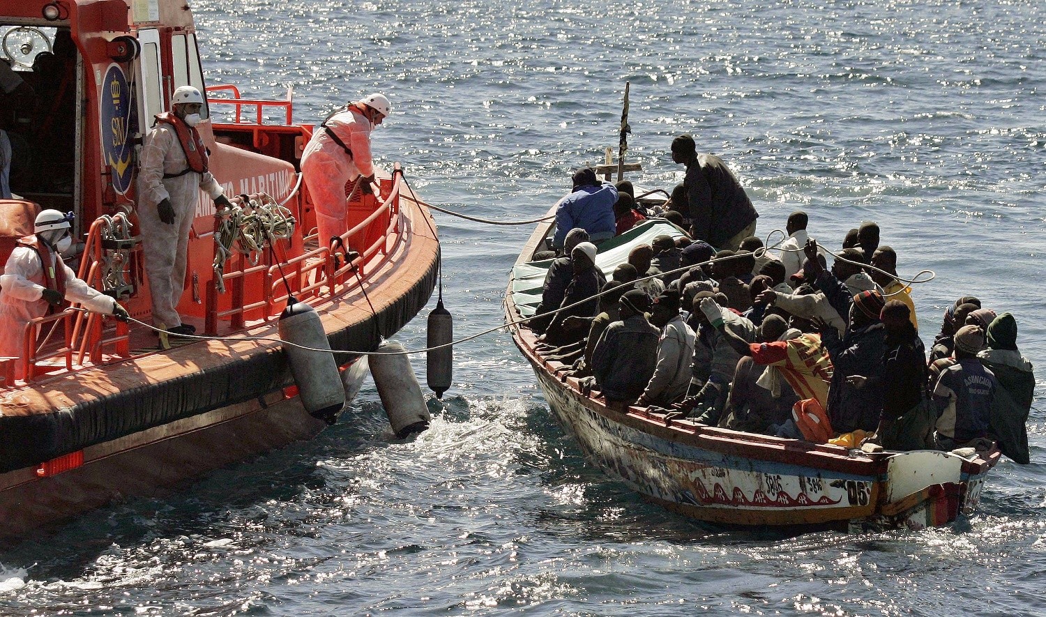 Un-barco-de-rescate-asiste-a-una-embarcacion-con-inmigrantes Contra el tráfico de personas