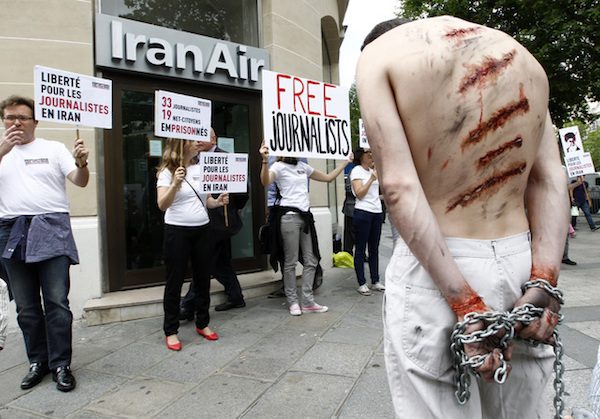 an-activist-from-reporters-without-borders-with-fake-injuries-and-chains-attends-a-demonstration-on-champs-elysees-avenue-in-front-of-the-iran-air-airline-company-in-paris-600x419 Irán: defensores de derechos humanos son enemigos del Estado