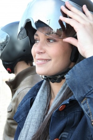 13977550-a-woman-turning-up-her-motorcycle-helmet-visor Recomendaciones de seguridad para motos