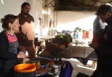 Activista de Coín en Transición vende verduras y esponjas de mar en un puesto del mercado de Málaga Común. Inés Benítez/IPS