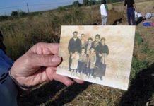 Un familiar muestra la foto de un desaparecido durante una exhumación en Berlangas de Roa, Burgos. © Francisco Etxeberría