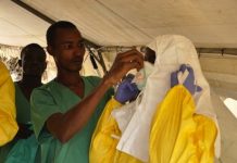 Miembros del equipo de MSF en Guinea poniéndose el traje protector antes de entrar al hospital. © Amandine