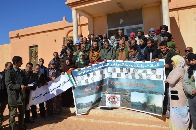 Periodistas saharauis despliegan pancarta de solidaridad con los presos del campamento Gdeim Izik.