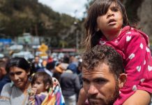 UNICEF/Arcos Laila Dalila León, de tres años, mira hacia la aduana colombiana en Rumichaca, en el frontera entre Colombia y Ecuador, sentada sobre los hombros de su padre.