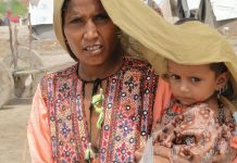 PNUD/Hira Hashmey: Una mujer cubre a su hija para protegerla del calor extremo en Sindh, Pakistán.