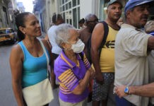 Sonia Gálvez, de 87 años y entre el grupo de mayor riesgo de contagio del coronavirus, se protege con una mascarilla mientras espera para comprar algunos medicamentos en una farmacia de La Habana, en Cuba. Foto: Jorge Luis Baños/IPS