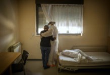 Una anciana se abraza a una trabajadora en la habitación donde permanece confinada