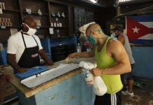 Un cliente paga unos productos racionados que se expenden a través de la libreta de abastecimiento en una bodega del municipio Playa, en La Habana. El aumento de los salarios y pensiones eliminará en Cuba los precios subsidiados de la cuota básica de alimentos y otros productos que el Estado oferta cada mes a los 11,2 millones de cubanos, mediante una cartilla de racionamiento instituida en 1962. © Jorge Luis Baños/IPS