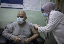 Trabajadores sanitarios administran la primera dosis de la vacuna COVID-19 a personas refugiadas en la Clínica de Vacunación de Irbid, en Jordania. © ACNUR/Jose Cendon