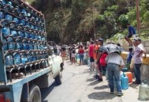 La escasez de agua en Caracas continúa forzando a habitantes de las barriadas populares a formar largas filas para llenar unos pocos bidones en algunas tomas a orillas de las vías. Comprar agua de garrafones resulta cada vez más costoso en medio de la profunda crisis socioeconómica en que está hundida Venezuela. Foto: Humberto Márquez /IPS