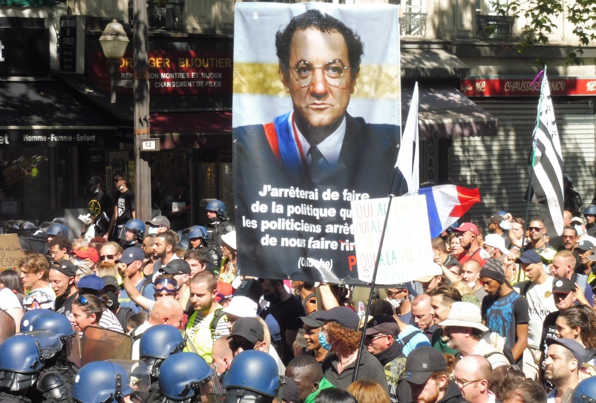 francia-parís-14ago2021-pancarta-coluche-pase-sanitario Francia: fuerte movilización contra el «pase sanitario» de Macron