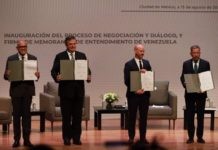 Negociadores del gobierno y la oposición de Venezuela muestran el memorando de entendimiento recién firmado, durante la apertura del diálogo en Ciudad de México. Foto: Gobierno de México