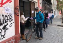 Un ciclista encabeza una fila que desde temprano aguarda para obtener un ejemplar gratuito del texto propuesto de la nueva Constitución, en una oficina de la calle de Villavicencio, en Santiago de Chile, donde en una semana repartieron 20 000 ejemplares, con el único requisito de informar su edad y sexo. © Orlando Milesi / IPS