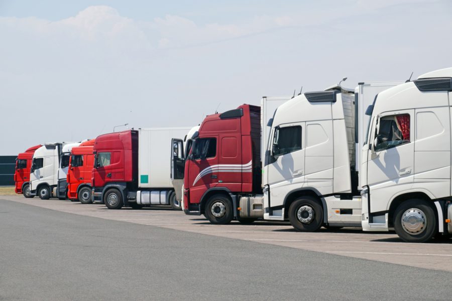 resting-place-various-types-of-trucks-in-the-parking-lot-next-to-the-motorway-900x599 Los profesionales del transporte deben conocer los símbolos del tacógrafo digital