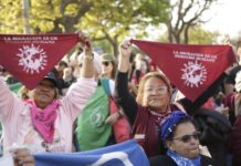 “La migración es un derecho”, destacan los pañuelos que sostienen dos mujeres en una manifestación en la capital argentina por los derechos de los migrantes. A la izquierda, Natividad Obeso, una peruana que llegó a Buenos Aires en 1994, huyendo de la violencia política de entonces en su país. © Camilo Flores / ACDH