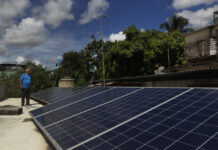 Félix Morfis, junto a paneles fotovoltaicos instalados en su vivienda, en el municipio Regla, en La Habana ©Jorge Luis Baños /IPS