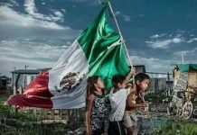 Niños mexicanos juegan con la bandera del país