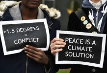 Activistas en Francia sostienen carteles en los que piden una solución para reducir las temperaturas a 1,5°. Foto: ANDES/AFP