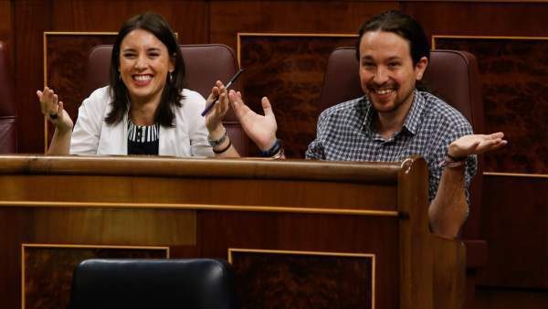 Irene Montero y Pablo Iglesias siguen un debate parlamentario en sus escaños en el Congreso