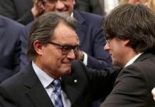 Artur Mas y Carles Puigdemont se saludan tras el pleno de investidura de nuevo presidente de la Generalitat