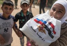 Niños de Alepo reciben la ayuda humanitaria procedente de Armenia aunque luzca la bandera rusa.