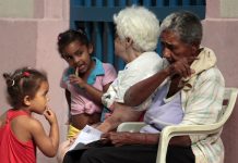 Dos abuelas con sus nietas a las que cuidan mientras sus madres trabajan, en una calle del casco histórico de la Habana Vieja, en Cuba. Los abuelos y abuelas trabajadores son incluidos en los beneficios de las nuevas normas para estimular la maternidad. Crédito: Jorge Luis Baños/IPS