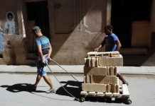 Dos jóvenes transportan bloques de construcción artesanal destinados a la ampliación de una vivienda en La Habana Vieja, en Cuba. Crédito: Jorge Luis Baños/IPS