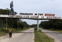 Imagen de un Fidel Castro joven y combatiente sobre un pequeño puente en una de las carreteras de acceso al puerto de Mariel, junto con una consigna donde se lee: "Comandante en jefe ordene". Frases emblemáticas, imágenes o fotografías del líder de la Revolución Cubana son habituales en los espacios públicos de Cuba, una década después de haber dejado el poder. Crédito: Jorge Luis Baños/IPS