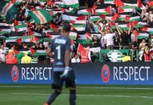 Grada de la Green Brigade con banderas palestinas.