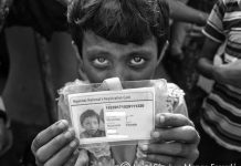 13/NOV2017. Campo de refugiados de Balukhli. Bangladesh: Pequeña rohinyá Una niña Rohinyá muestra la tarjeta de identidad con nacionalidad birmana expedida por las autoridades de Bangladesh (he ocultado sus datos) y que se ven obligados a tener todos los Rohinyás residentes en sus campos de refugiados. Si bien esta tarjeta le da derecho al reconocimiento de su estatuto de refugiada, no le permite salir del campo ni dirigirse hacia ningún otro punto del país, en donde se encuentra transitoriamente hasta que algún día pueda ser reconocida su nacionalidad. Aunque ella nació en el estado Birmano de Rajine, el gobierno Birmano rechaza reconocer su ciudadanía, lo que le otorga la singular condición de ser una apátrida.