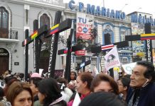 Un grupo de manifestantes con cruces negras, simbolizando las víctimas de feminicidio en Perú y otros países latinoamericanos, pasan por una calle del centro de Lima, durante la multitudinaria marcha celebrada el 13 de agosto bajo la consigna "Ni Una Menos". Crédito: Noemí Melgarejo/IPS