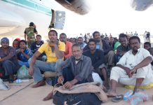 Migrantes africanos en Kufra, en Libia, poco antes de ser llevados a un avión de carga, tras ser retenidos antes de lograr llegar a Europa atravesando el mar Mediterráneo, donde muchos pierden la vida. Crédito: Rebecca Murray/IPS